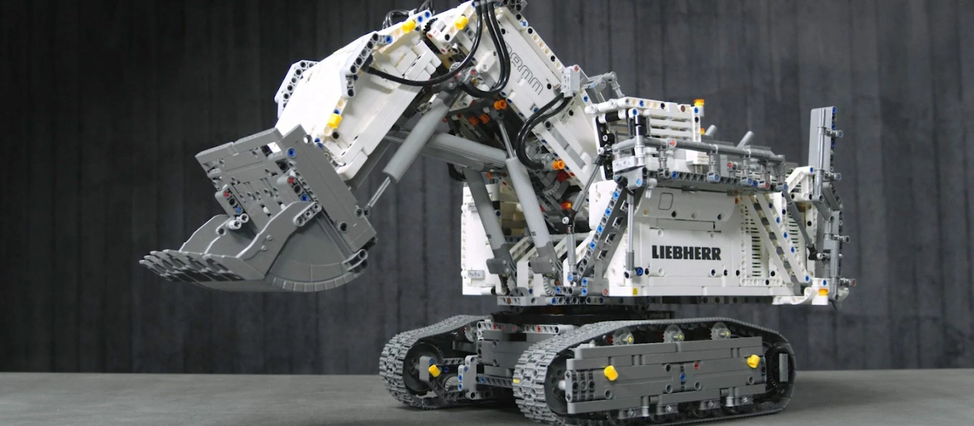 Sastavljen belo-sivi Lego model bagera Liebherr R 9800 sa gusenicama i podignutom ka&scaron;ikom.